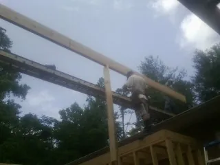 Carpenter setting a ridge beam over a new addition frame — Ice Dam Removal by Roofing Brothers in Sherman