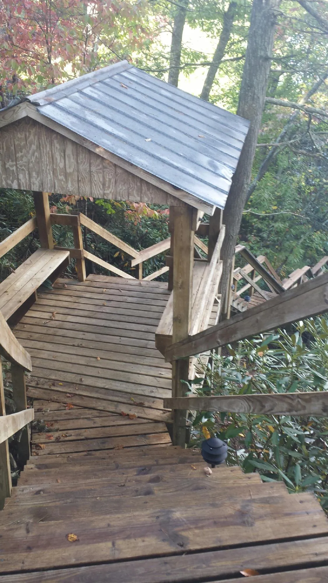 Metal roofed shelter over wooden steps on a wooded walkway — Skylight Repair & Installation work by our crew in Sherman